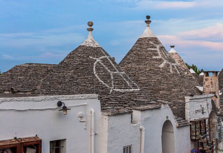 Téléchargez les photos : Alberobello, Pouilles, Italie : Maisons typiques construites avec des murs en pierre sèche et des toits coniques, dans une belle journée, Pouilles - en image libre de droit