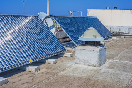 Téléchargez les photos : Chauffe-eau solaire installé sur la terrasse d'un bâtiment - en image libre de droit