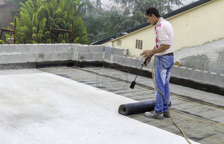 Téléchargez les photos : Travaux de réparation de couverture de toit plat avec feutre de toiture - en image libre de droit