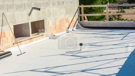 Photo for Worker applies pvc membrane roller on roof very carefully. Correct welding with hand-welder, corner. - Royalty Free Image