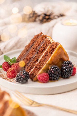 Photo for Delicious semi-naked chocolate cake with caramel topping and decorated with blackberries and raspberries. Light background - Royalty Free Image