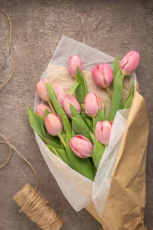 Téléchargez les photos : Bouquet de fleurs de tulipe rose sur fond gris. Couché à plat, vue de dessus. Concept floral printanier. - en image libre de droit