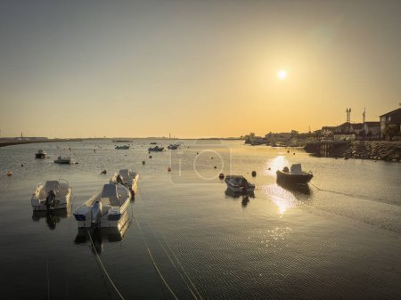 Photo for Some fishing boats moored at the pier in Sao Jacinto at sunset in Aveiro, Portugal - Royalty Free Image