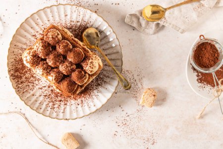 Tradition italienne en couches tiramisu dessert avec crème de mascarpone et biscuits ladyfingers saupoudrés de cacao en poudre sur un fond blanc. Vue du dessus