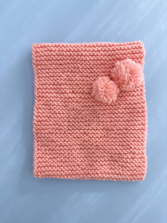 Weiche rosa Spitze gestrickter runder Schal isoliert auf pastellblauem Hintergrund. Mode als Accessoire für Kinder