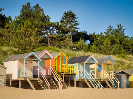 Photo for 29 June 2019: Wells-Next-The-Sea, Norfolk, England, UK - Bathing huts on the beach, trees behind. - Royalty Free Image