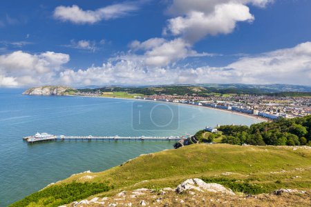 Photo for Llandudno, the pier and the Little Orme, from the Great Orme in summer. Popular seaside resort, the UKs second most popular, was built in the 19th century and has kept its Victorian charm. - Royalty Free Image
