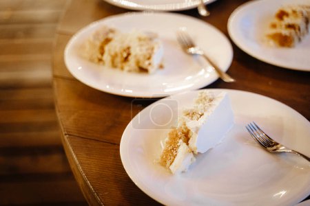 Photo for Delicious pieces of cake on the plates on wooden table - Royalty Free Image