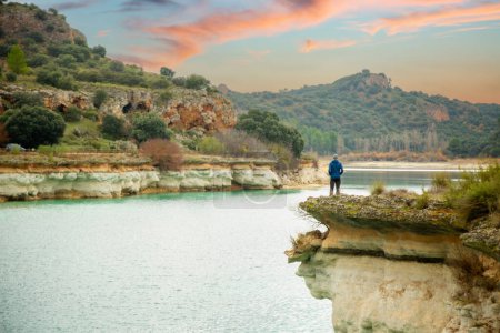 Téléchargez les photos : Personne seule contemplant le lac depuis une falaise et profitant de la nature dans les lagunes de Ruidera, Espagne. Voyager seul pour se détendre. - en image libre de droit
