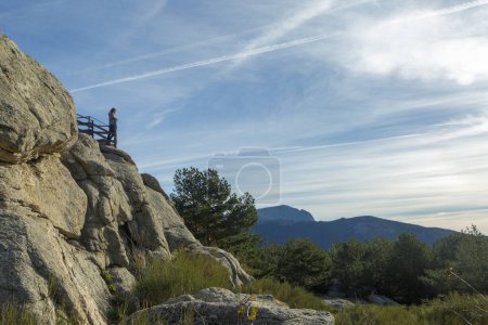 Silhouette einer Frau, die von einem Aussichtspunkt im Nationalpark Sierra de Guadarrama die Landschaft in den Bergen genießt. In Cercedilla, Madrid, Spanien
