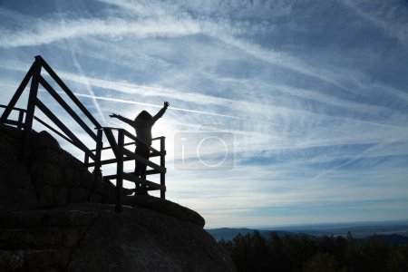 Silueta de una mujer disfrutando del paisaje de las montañas desde un mirador en el Parque Nacional Sierra de Guadarrama. En Cercedilla, Madrid, España