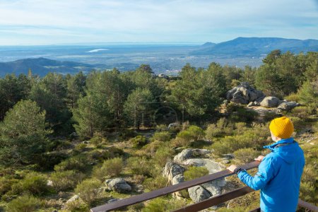 Man enjoying the mountain landscape at a viewpoint in the Sierra de Guadarrama National Park. In Cercedilla, Madrid. Spain