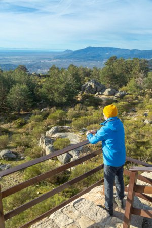 Hombre disfrutando del paisaje montañoso en un mirador del Parque Nacional Sierra de Guadarrama. En Cercedilla, Madrid. España