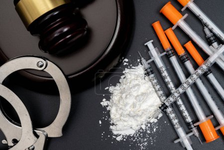 Drogenkriminalität mit weißem Pulver und Einmalspritze auf schwarzem Hintergrund