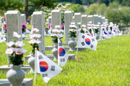 Paysage estival du cimetière national de Séoul avec pierres tombales et drapeau coréen sur pelouse verte