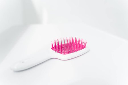 Téléchargez les photos : Peigne blanc avec dents roses pour cheveux extensionshair sur fond isolé - en image libre de droit