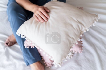 Photo for Top view, a doctor in a blue medical suit sits on the bed with his hands on the pillows. The concept of healthy sleep, meditation, lifestyle, healthcare, hospital - Royalty Free Image