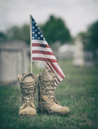 Old military combat boots against American flag. Memorial Day or Veterans Day, sacrifice concept.