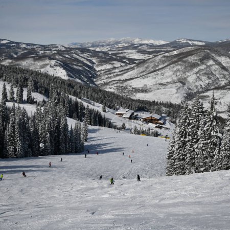 Téléchargez les photos : Beautiful sunny day and amazing winter landscape around at the Vail Mountain Ski Resort, Colorado. Skiers and snowboarders riding down the slope. - en image libre de droit