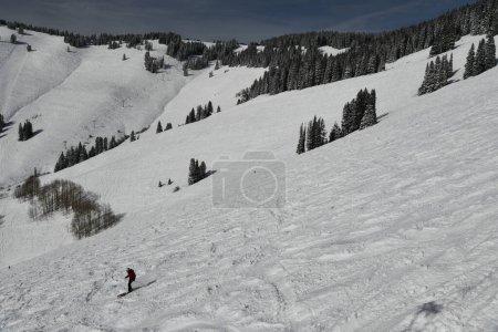 Photo for Beautiful view of winter mountain slope covered with fresh snow and active skier quickly moving down. Vail Ski Resort, Colorado. - Royalty Free Image