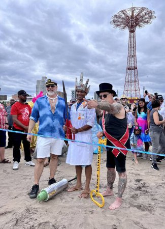 Téléchargez les photos : NEW YORK - JUNE 18, 2022: Dr. Dave A. Chokshi (C), Dick Zigun (R) at the ceremony of opening summer season during the 40th Annual Mermaid Parade at Coney Island, the largest parade in the nation and a celebration of ancient mythology on June 18, 2022 - en image libre de droit