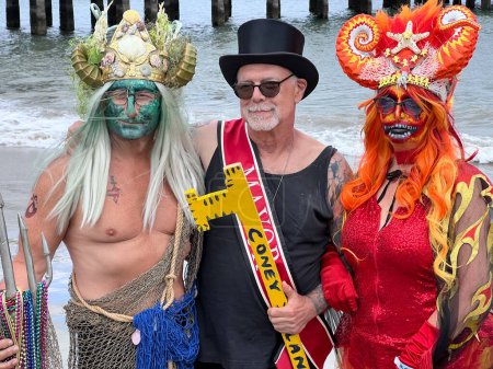 Foto de NEW YORK - JUNE 18, 2022: Dick Zigun (C) and participants pose during the 40th Annual Mermaid Parade at Coney Island, the largest parade in the nation and a celebration of ancient mythology on June 18, 2022 in Brooklyn NY. - Imagen libre de derechos