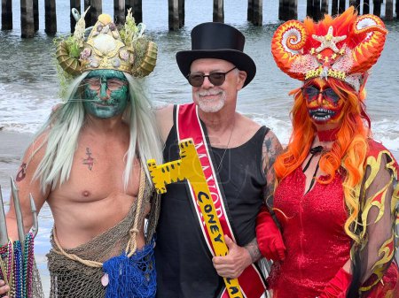 Foto de NEW YORK - JUNE 18, 2022: Dick Zigun (C) and participants pose during the 40th Annual Mermaid Parade at Coney Island, the largest parade in the nation and a celebration of ancient mythology on June 18, 2022 in Brooklyn NY. - Imagen libre de derechos