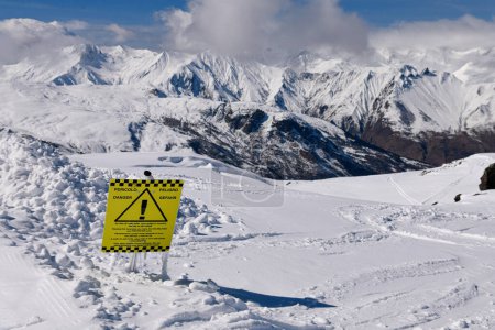 Téléchargez les photos : Neige fraîche et signe de danger sur le terrain hors piste du domaine skiable de Meribel avec vue imprenable sur les sommets alpins. Belle journée ensoleillée d'hiver. - en image libre de droit