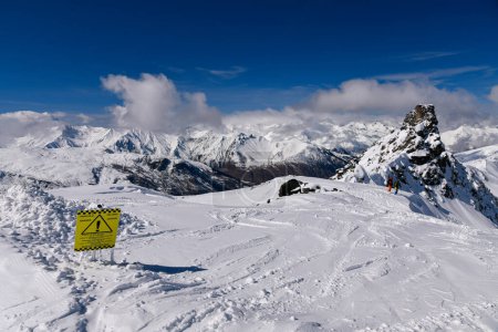 Téléchargez les photos : Neige fraîche et signe de danger sur le terrain hors piste du domaine skiable de Meribel avec vue imprenable sur les sommets alpins. Belle journée ensoleillée d'hiver. - en image libre de droit