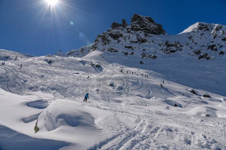 Photo for Sunny winter day and great snow conditions at the Meribel ski resort in France. Advanced skiers exploring off piste terrain with breathtaking landscape around. - Royalty Free Image
