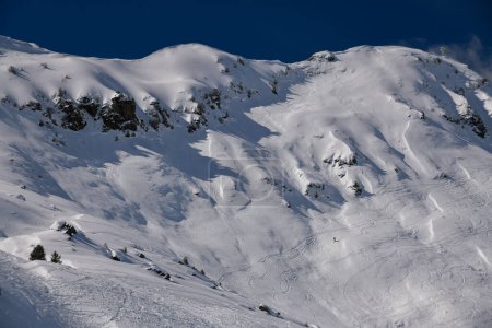 Téléchargez les photos : Les skieurs explorent le terrain hors piste à la station de ski Meribel en France. Belle journée ensoleillée d'hiver et paysage étonnant autour. - en image libre de droit