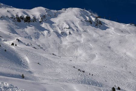 Téléchargez les photos : Les skieurs explorent le terrain hors piste à la station de ski Meribel en France. Belle journée ensoleillée d'hiver et paysage étonnant autour. - en image libre de droit
