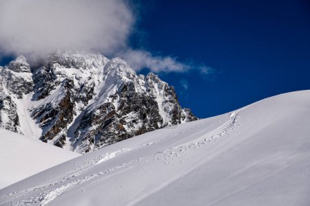 Téléchargez les photos : Pistes de ski sur neige fraîche au domaine hors piste de la station de ski Meribel en France. Beautul vue sur les montagnes en arrière-plan. - en image libre de droit
