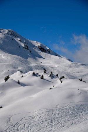 Photo for Ski tracks on the off piste terrain at the Meribel Ski Resort in France. Beautiful sunny day with blue sky. - Royalty Free Image
