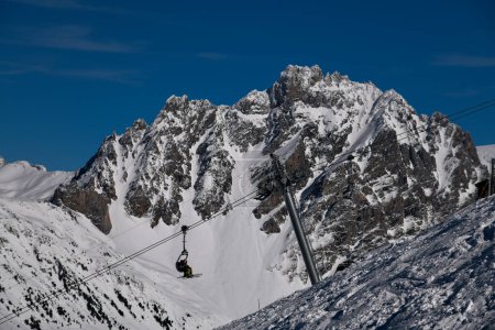 Photo for Skiers going up on the chairlift at the Meribel ski resort in France. Breathtaking landscape. Winter vacation in Europe and active lifestyle. - Royalty Free Image