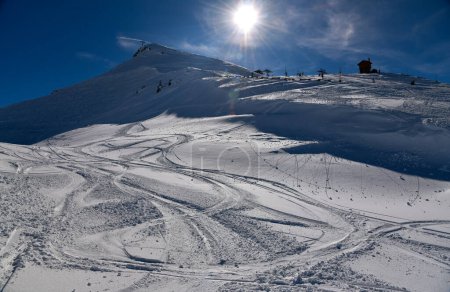 Téléchargez les photos : Pistes de ski sur neige fraîche au domaine hors piste de la station de ski Meribel en France. Belle vue sur les montagnes en arrière-plan. - en image libre de droit