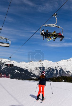 Téléchargez les photos : Vacances d'hiver et ski à la station de ski Courchevel en France. Belle journée ensoleillée et vue imprenable sur les Alpes en arrière-plan. - en image libre de droit