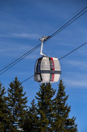 Téléchargez les photos : COURCHEVEL- 16 MARS : Ski en gondole sur fond de ciel bleu et de pins lors de la belle journée d'hiver du 16 mars 2023 à Courchevel, France. - en image libre de droit