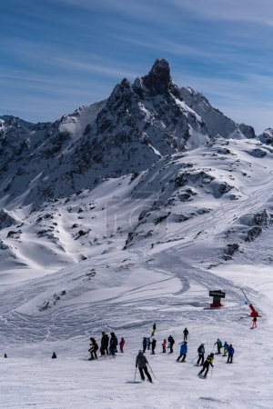 Téléchargez les photos : Vacances d'hiver à la station de ski Courchevel par une belle journée ensoleillée. Les gens descendent la pente avec un paysage incroyable autour. - en image libre de droit