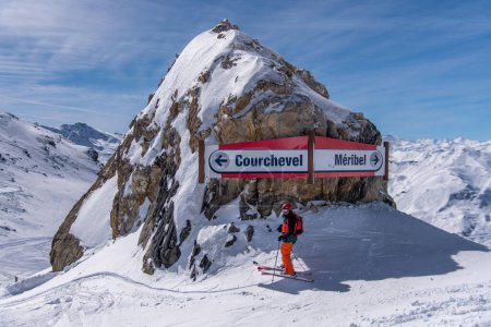 Téléchargez les photos : Skieur posant au panneau Courchevel Meribel par une belle journée d'hiver. - en image libre de droit