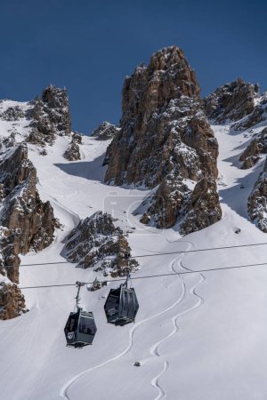 Téléchargez les photos : MERIBEL- 15 MARS : Ski en gondole sur les pistes de neige et les montagnes en arrière-plan le 15 mars 2023 à Meribel, France. - en image libre de droit