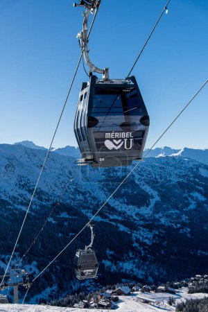 Photo for MERIBEL- MARCH 15: Ski gondola over blue sky and mountains on the background on March 15, 2023 in Meribel, France. - Royalty Free Image