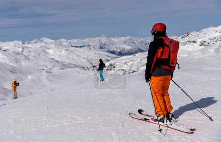 Photo for Skiers riding down the slope at the Val Thorens Ski resort in France. Village in the middle of the valley. - Royalty Free Image