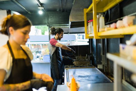Foto de Chef mexicano y cocinero trabajando juntos preparando la comida rápida en el camión de comida - Imagen libre de derechos