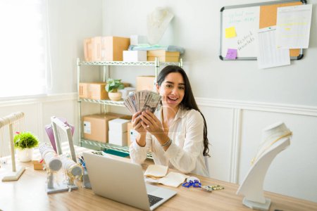 Téléchargez les photos : Femme entrepreneure excitée avec une boutique en ligne réussie faisant beaucoup d'argent travaillant à la maison - en image libre de droit
