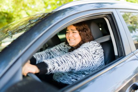 Foto de Mujer obesa ansiosa asustada que parece estresada mientras golpea los frenos del coche y se detiene mientras conduce - Imagen libre de derechos