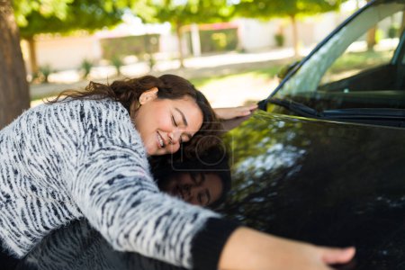 Téléchargez les photos : Femme obèse excitée souriant regardant heureux étreignant la voiture après avoir acheté une nouvelle voiture - en image libre de droit