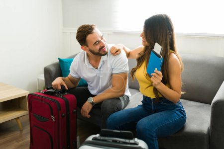 Foto de Sonriendo hermosa pareja usando sus maletas y pasaportes mientras se preparan para viajar de vacaciones juntos - Imagen libre de derechos