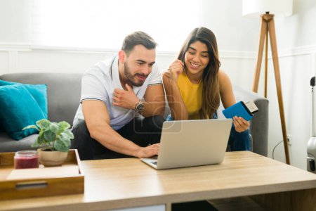 Téléchargez les photos : Homme caucasien et femme latine regardant en ligne sur l'ordinateur portable lors de la planification d'un voyage et la réservation de vacances - en image libre de droit