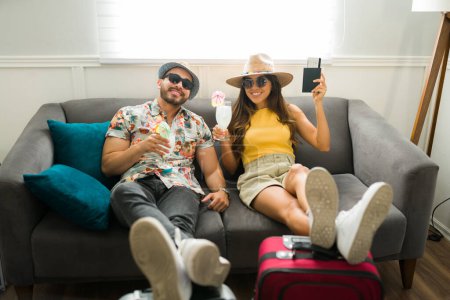 Téléchargez les photos : Joyeux couple heureux prêt pour leurs vacances d'été à la maison avec leurs valises emballées - en image libre de droit